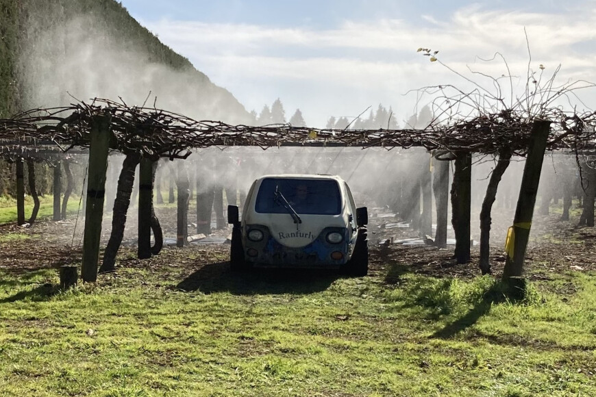 Spraying in progress in the kiwifruit orchard. Plastic covers were used to protect the soil surface and provide unsprayed controls.